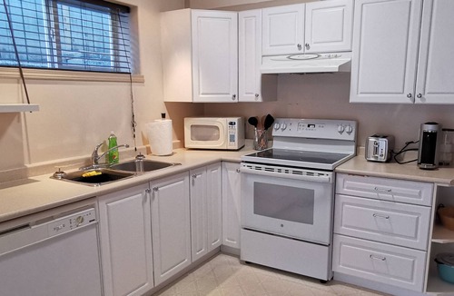 Saanich West House | Private 2 Bedroom Suite with one bed and a crib
