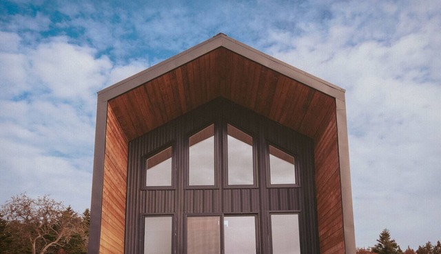 A sanctuary of architectural restraint, unmediated coastal observation, and premium electric travel infrastructure.